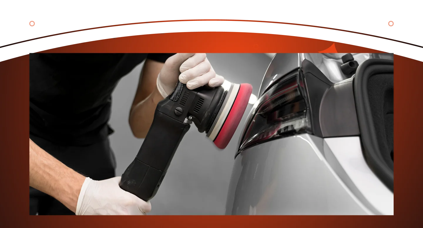 Um profissional de estética automóvel está polindo uma lanterna traseira com uma politriz elétrica para restaurar o brilho e a transparência.